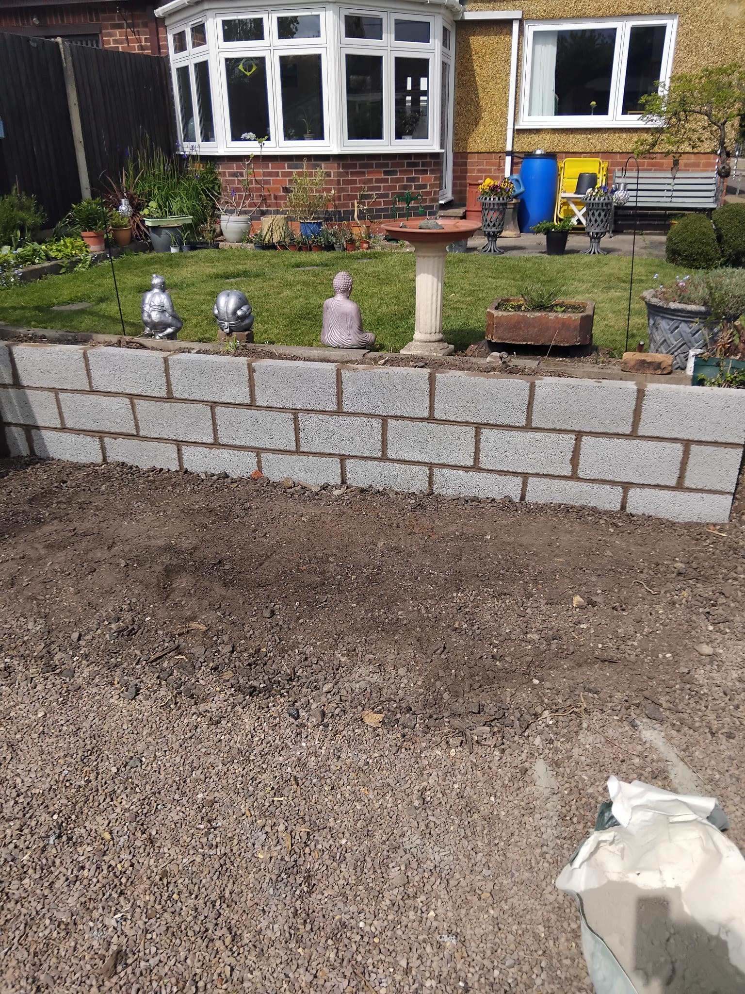 Grey block garden wall in front garden of brick house