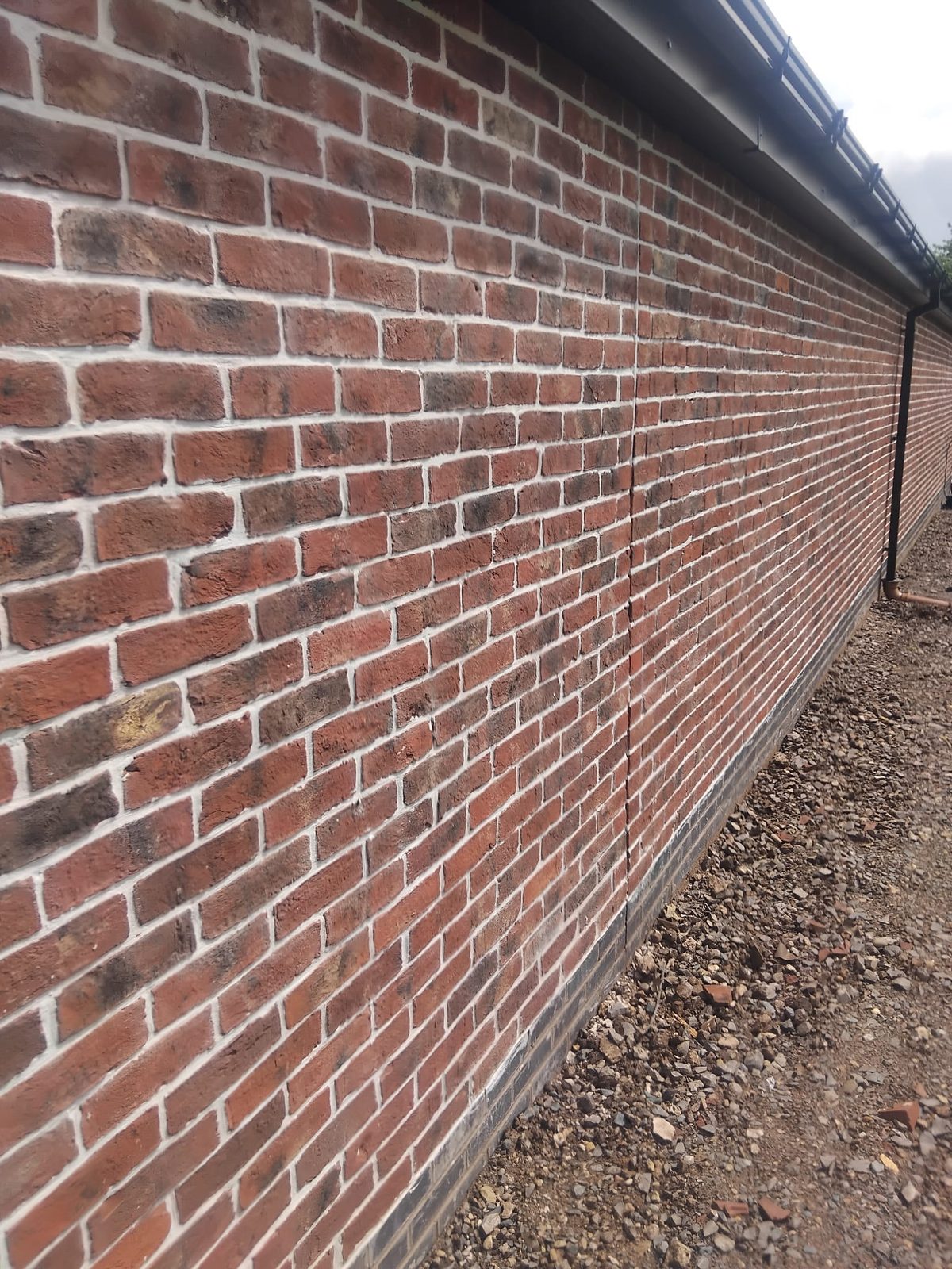Long red brick boundary wall built by C.M Brickwork
